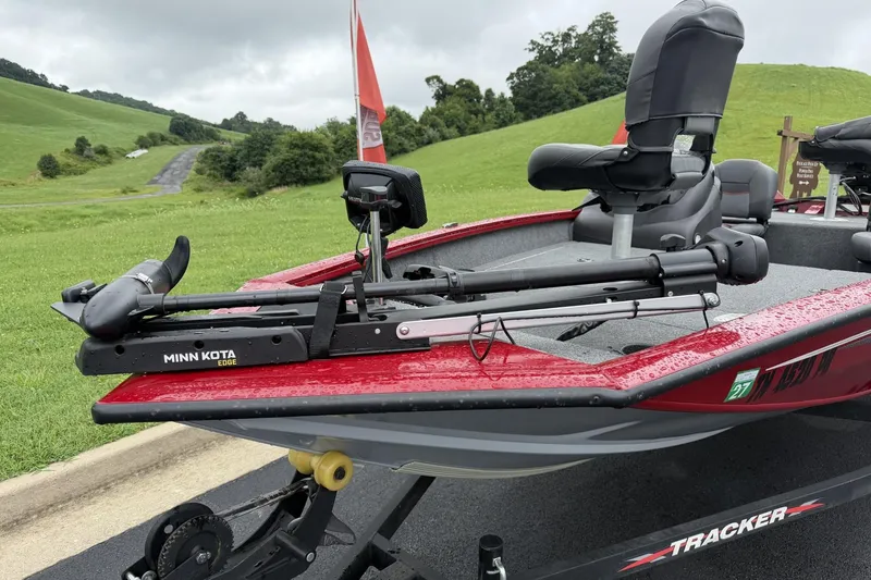 Slide: The Image of 2024 Tracker Pro Team 175 TF boat with Minn Kota Edge trolling motor on a grassy landscape. - 7