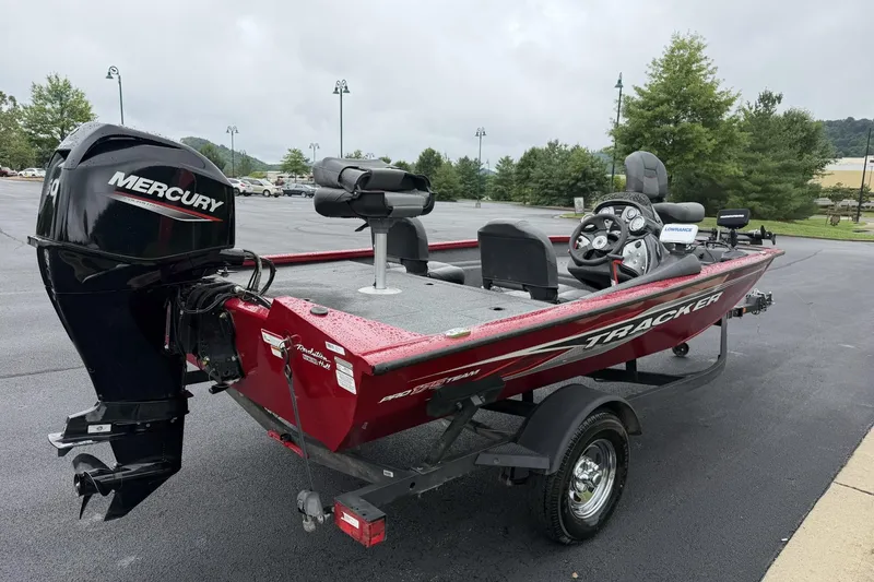 Slide: The Image of 2024 Tracker Pro Team 175 TF fishing boat with Mercury engine, parked outdoors. - 5