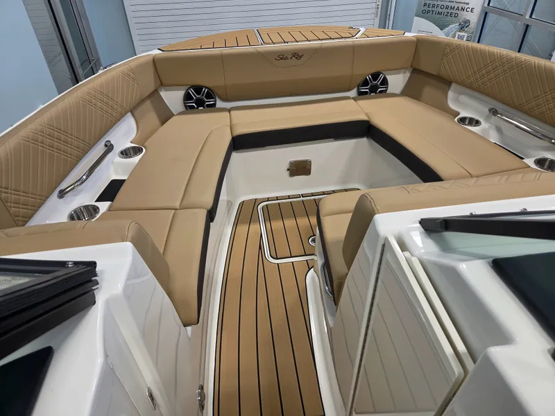 Slide: The Image of The image shows the interior of a 2027 Sea Ray SDX 270 Surf with elegant seating and wood flooring. - 25