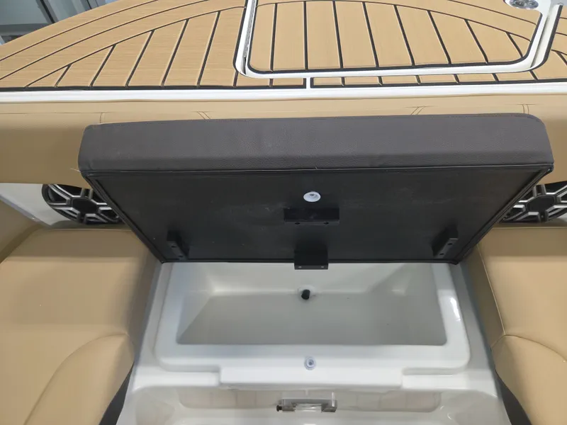 Slide: The Image of An open storage compartment on a Sea Ray SDX 270 Surf boat with cushioned seating. - 27