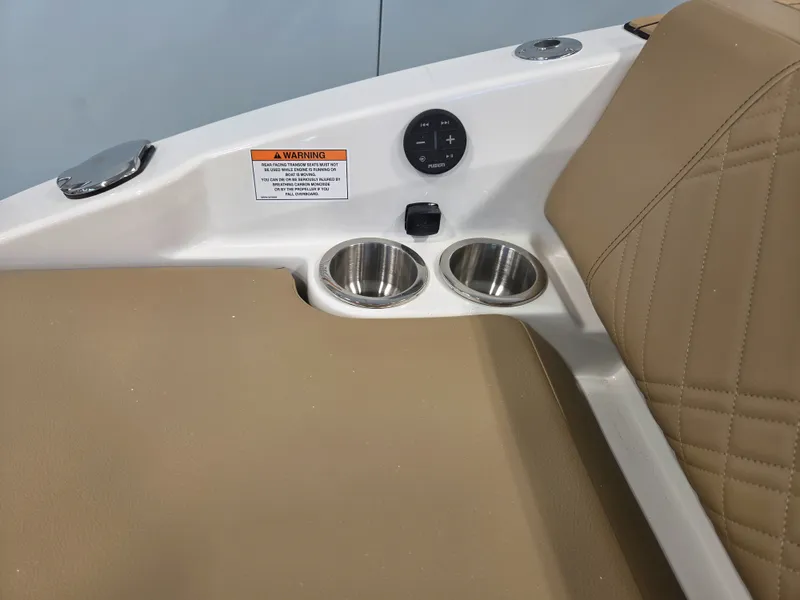 Slide: The Image of The image shows part of a Sea Ray SDX 270 Surf boat interior with beige upholstery and cup holders. - 39