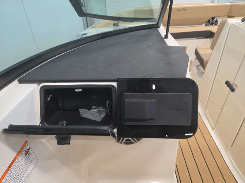 Slide: The Image of The image shows the dashboard of a Sea Ray SDX 270 Surf with an open storage compartment. - 19