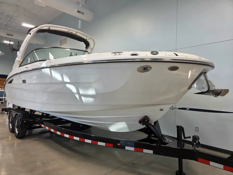 Slide: The Image of A 2027 Sea Ray SDX 270 Surf on a trailer in a showroom. - 1