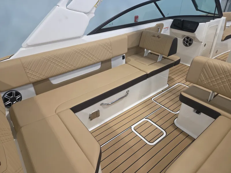 Slide: The Image of The image shows the interior of a Sea Ray SDX 270 Surf boat with beige seating and wood flooring. - 16
