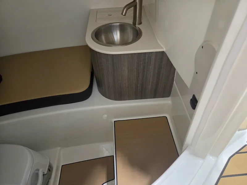 Slide: The Image of The image shows the interior of a 2027 Sea Ray SDX 270 Surf with a sink and seating area. - 22