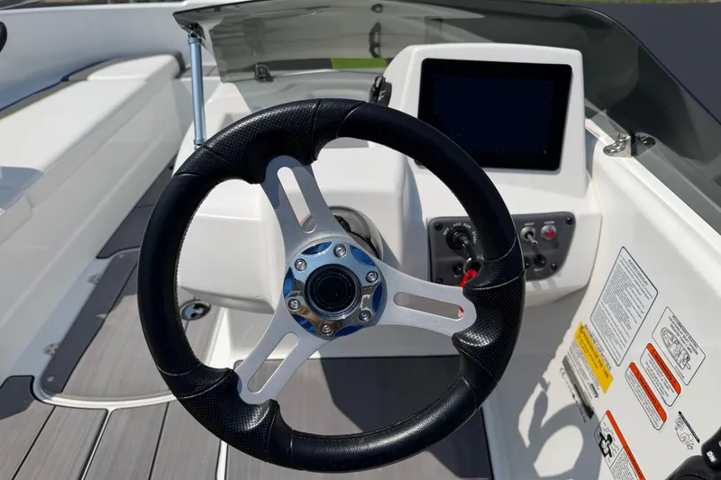 Slide: The Image of Steering wheel and dashboard of 2024 Tahoe T16 boat, featuring modern controls and display. - 8