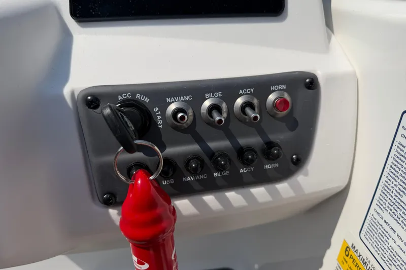 Slide: The Image of Control panel of 2024 Tahoe T16 boat with switches and ignition key. - 13