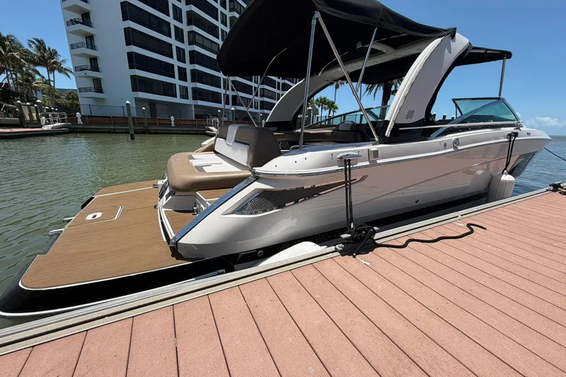 Slide: The Image of 2016 Four Winns H290 boat docked, featuring sleek design and spacious seating under a canopy. - 17