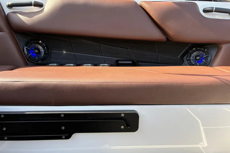 Slide: The Image of 2025 Moomba Max boat interior with brown seating and blue-lit speakers. - 23