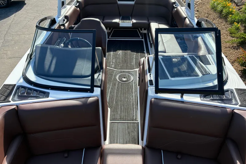 Slide: The Image of 2025 Moomba Max boat interior with open windshield and brown seating. - 36