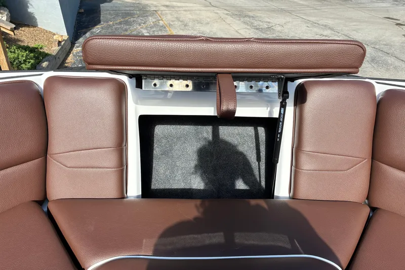 Slide: The Image of 2025 Moomba Max boat interior with brown leather seating and storage compartment. - 44