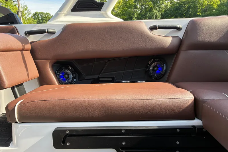 Slide: The Image of 2025 Moomba Max boat interior with brown seating and built-in speakers. - 21