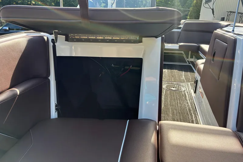 Slide: The Image of 2025 Moomba Max boat interior with open storage compartment and brown seating. - 39