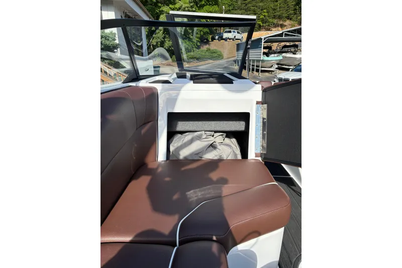 Slide: The Image of 2025 Moomba Max boat interior with brown seating and storage compartment. - 26