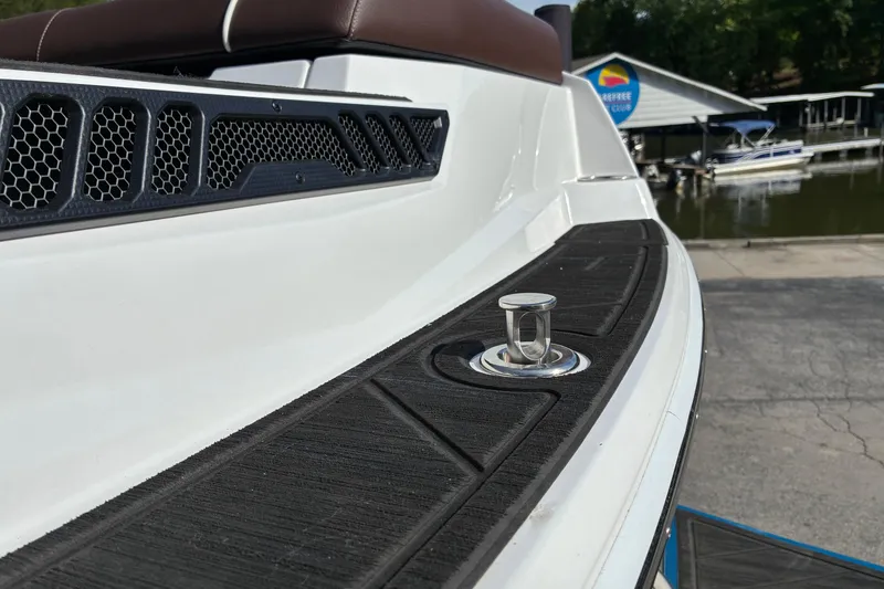 Slide: The Image of 2025 Moomba Max boat detail with sleek design and docked at a marina. - 9