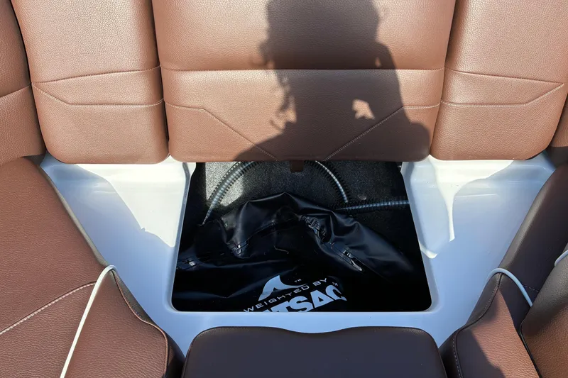 Slide: The Image of The image shows the interior of a 2025 Moomba Max with brown leather seats and an open storage compartment. - 43