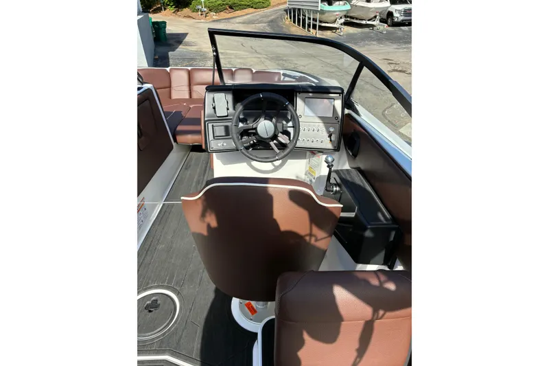 Slide: The Image of 2025 Moomba Max boat interior with steering wheel, dashboard, and brown seating. - 28