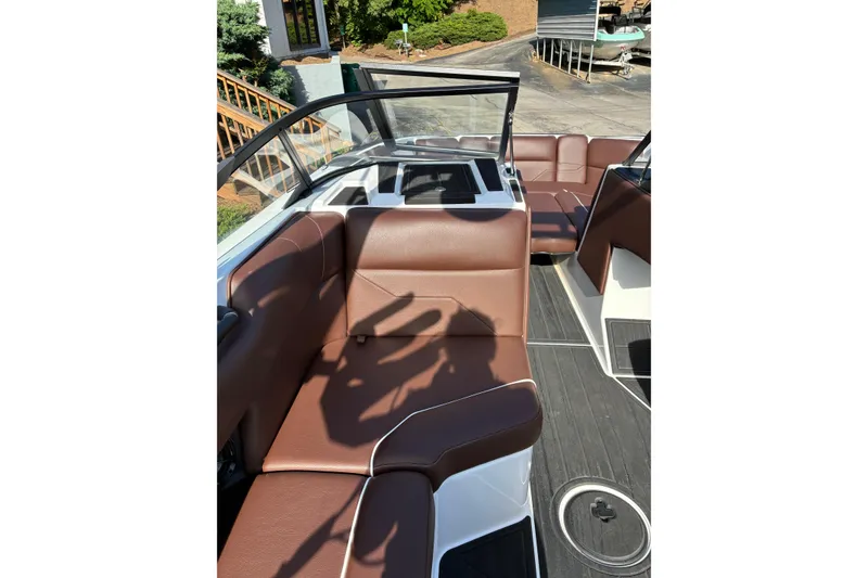 Slide: The Image of 2025 Moomba Max boat interior with brown leather seating and open windshield. - 25