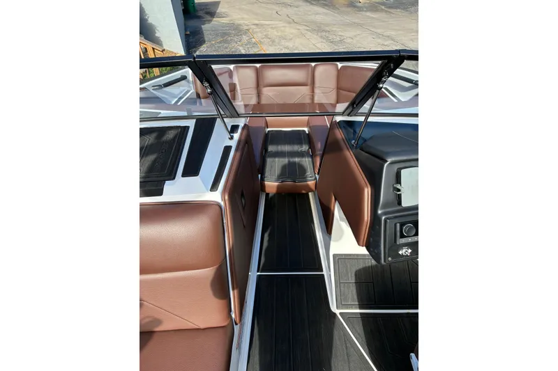 Slide: The Image of 2025 Moomba Max boat interior with brown seating and sleek black flooring. - 46
