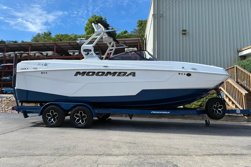 The Image of 2025 Moomba Max boat on trailer, parked outdoors near a building. - 0