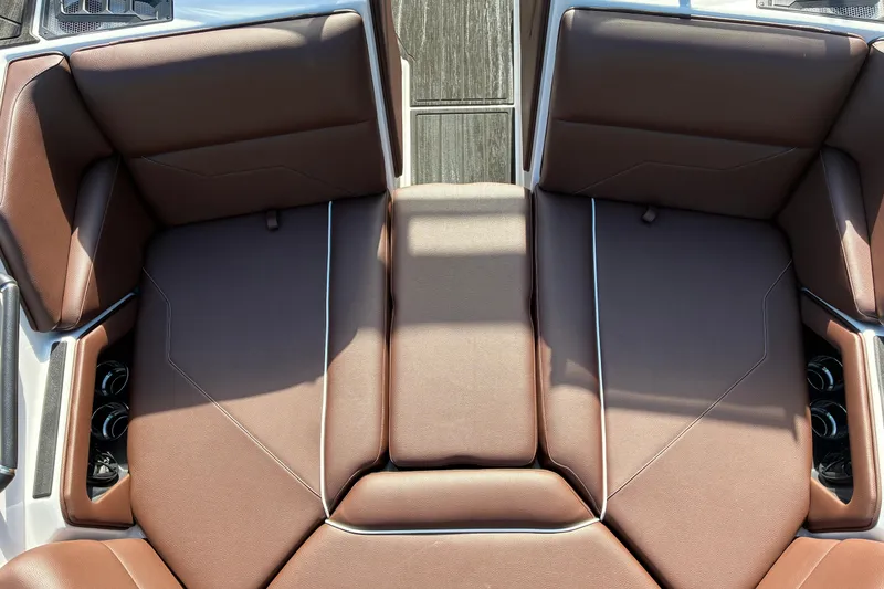Slide: The Image of 2025 Moomba Max boat interior with brown cushioned seating and cup holders. - 37