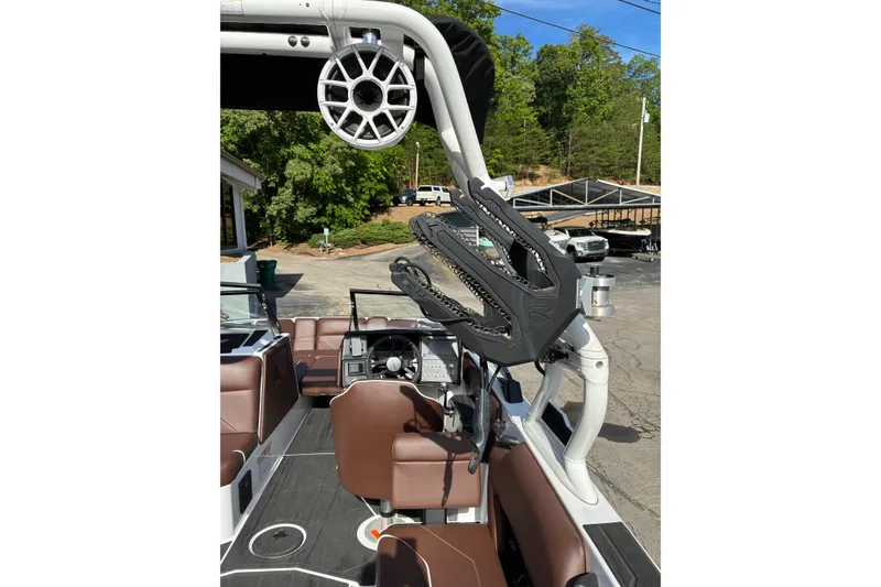 Slide: The Image of 2025 Moomba Max boat interior with brown seating and wakeboard rack. - 17