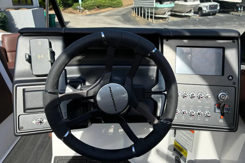 Slide: The Image of Steering wheel and dashboard of 2025 Moomba Max boat, featuring control panel and touchscreen. - 29