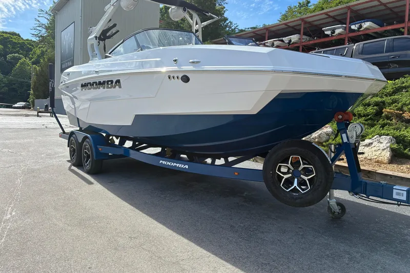 Slide: The Image of 2025 Moomba Max boat on trailer at marina, featuring sleek design and modern aesthetics. - 3