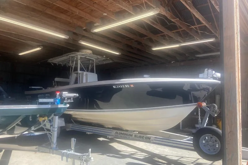 Slide: The Image of 2005 Contender 31 Open boat on trailer in a well-lit garage. - 4