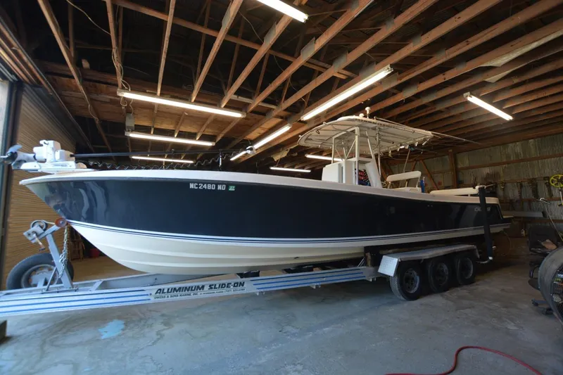 Slide: The Image of 2005 Contender 31 Open boat on trailer in a wooden-ceiling garage. - 3