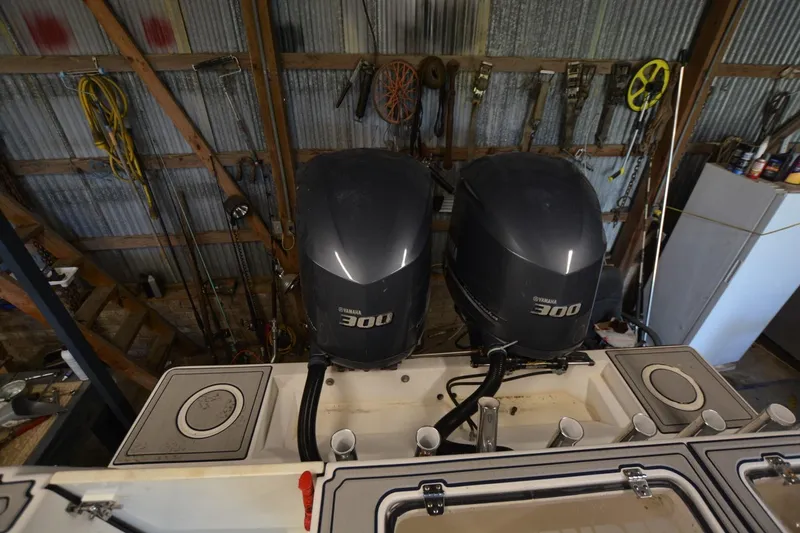 Slide: The Image of 2005 Contender 31 Open boat with dual Yamaha 300 engines in a workshop setting. - 16
