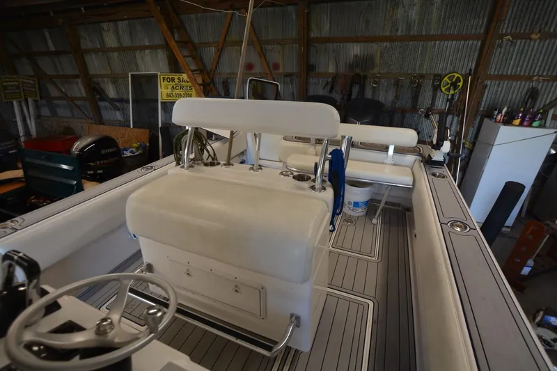 Slide: The Image of 2005 Contender 31 Open boat interior in storage, featuring seating and steering wheel. - 14