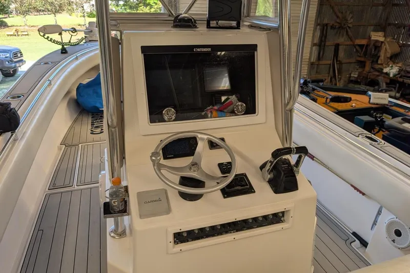 Slide: The Image of 2005 Contender 31 Open boat console with steering wheel and Garmin navigation system. - 17