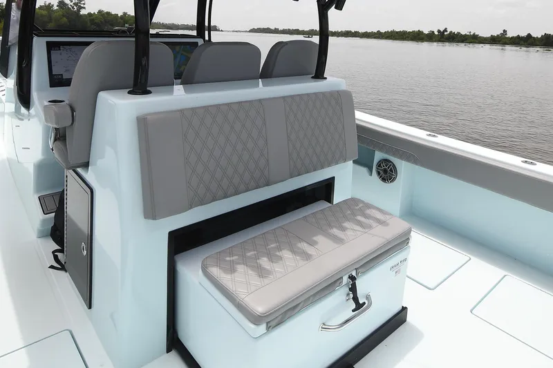Slide: The Image of 2024 Front Runner 37 Catamaran interior with cushioned seating and storage, on calm water. - 16