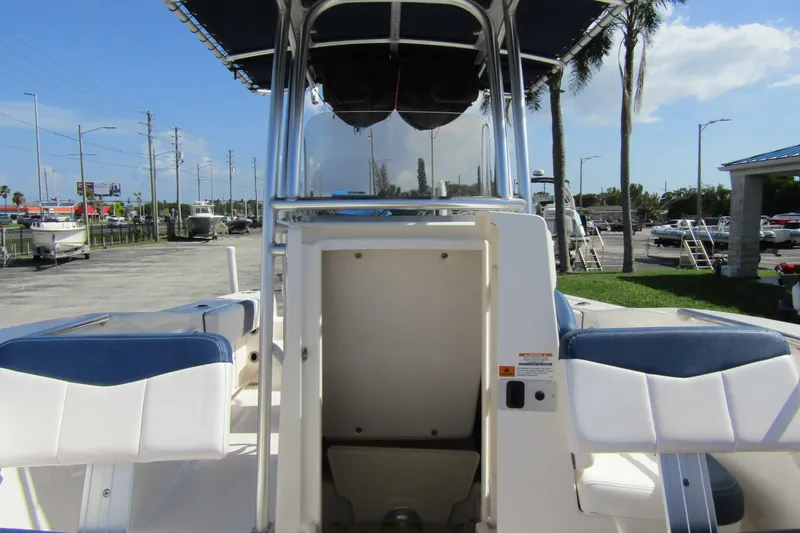 Slide: The Image of 2018 Robalo R202 Explorer boat interior with seating and console, parked outdoors. - 18
