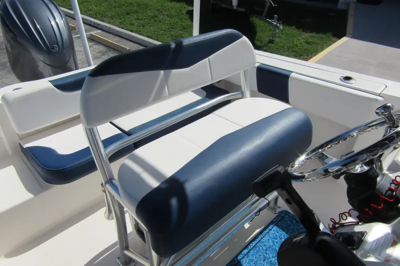 Slide: The Image of 2018 Robalo R202 Explorer boat interior with blue and white seating and steering wheel. - 29