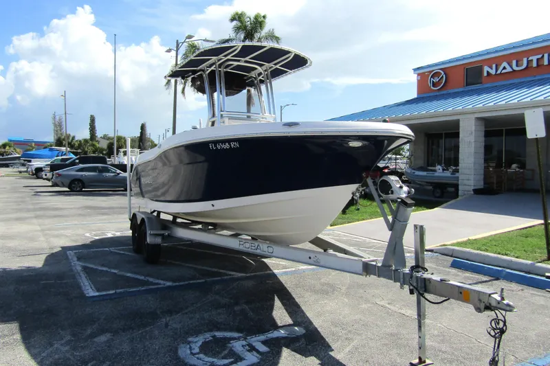 Slide: The Image of 2018 Robalo R202 Explorer boat on trailer in parking lot near dealership. - 2