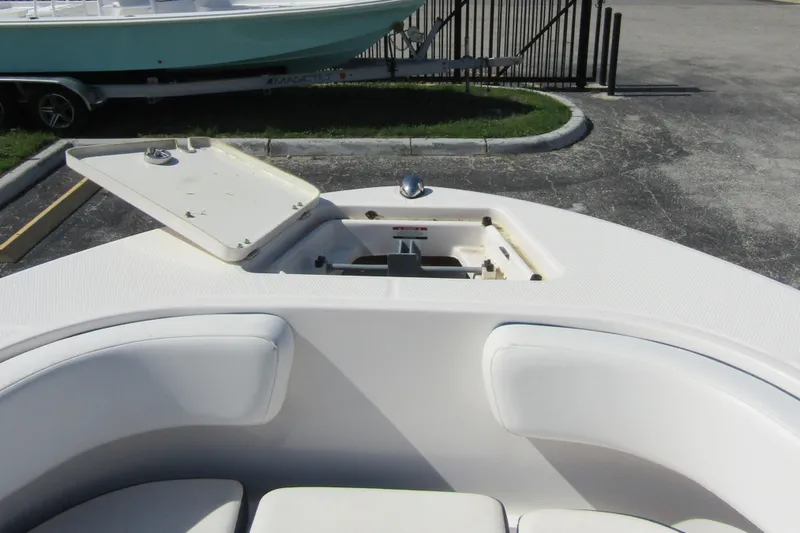 Slide: The Image of 2018 Robalo R202 Explorer boat with open anchor hatch, white seating, and docked nearby. - 22