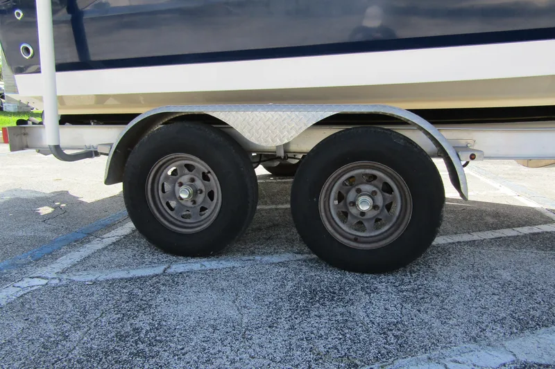 Slide: The Image of Trailer wheels of a 2018 Robalo R202 Explorer boat parked on concrete. - 12