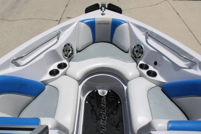 Slide: The Image of The image shows the bow of a 2008 Nautique 210 Team boat with blue and gray upholstery. - 5