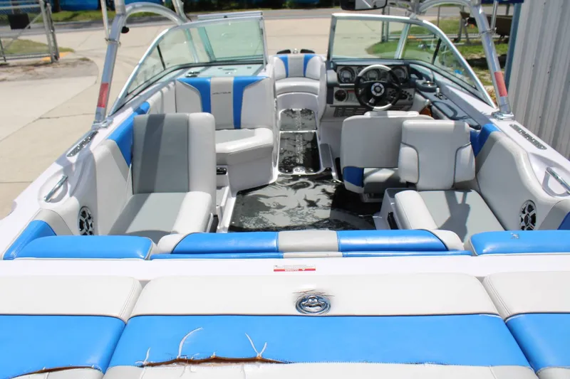 Slide: The Image of The image shows the interior of a 2008 Nautique 210 Team boat with blue and gray seating. - 11