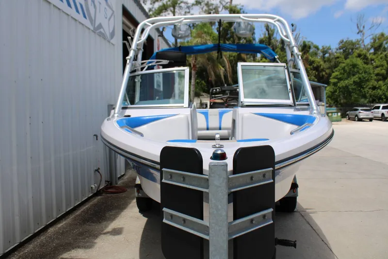 Slide: The Image of A 2008 Nautique 210 Team boat on a trailer in front of a building. - 3