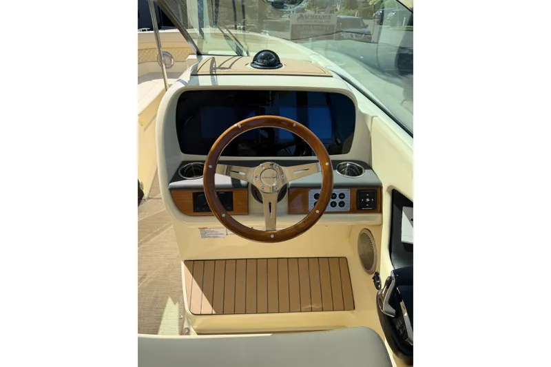 Slide: The Image of 2027 Chris-Craft Calypso 28 helm with wooden steering wheel and modern dashboard. - 16