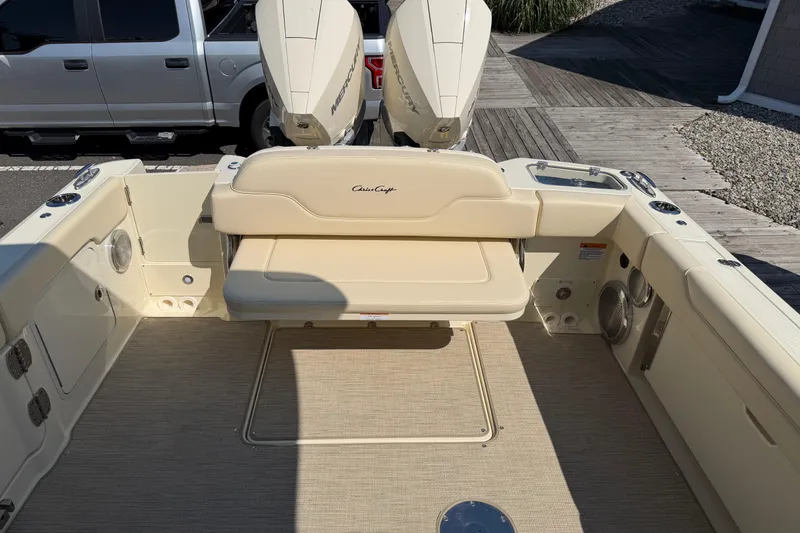 Slide: The Image of 2027 Chris-Craft Calypso 28 boat interior with beige seating and twin Mercury engines. - 37