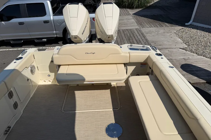 Slide: The Image of 2027 Chris-Craft Calypso 28 boat interior with beige seating and dual Mercury outboard engines. - 33