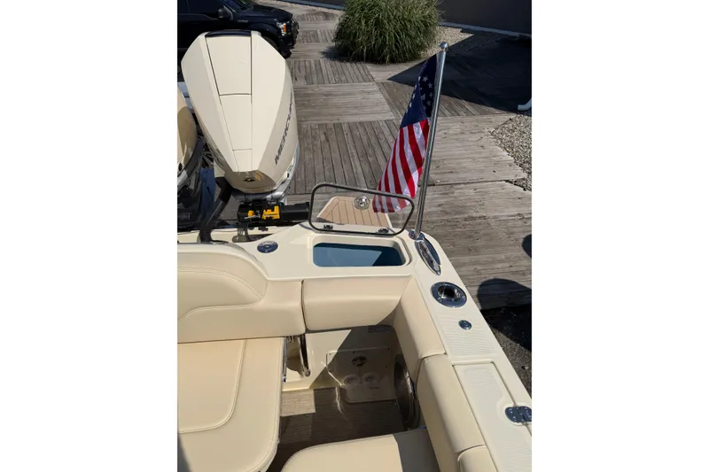 Slide: The Image of 2027 Chris-Craft Calypso 28 boat with American flag and Mercury engine on wooden dock. - 35