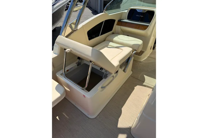 Slide: The Image of 2027 Chris-Craft Calypso 28 boat interior with beige seating and storage compartment. - 28
