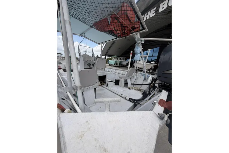Slide: The Image of 2012 Southfork 27 boat interior with steering console and seating, docked near other boats. - 8