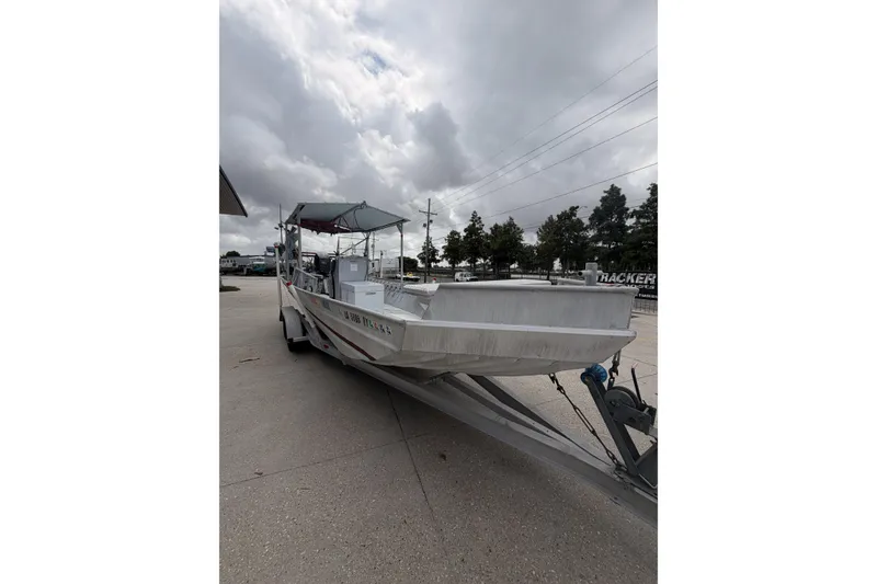 Slide: The Image of 2012 Southfork 27 boat on trailer under cloudy sky. - 4