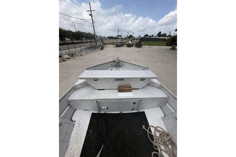 Slide: The Image of 2012 Southfork 27 boat on concrete lot, featuring storage box and coiled rope. - 10